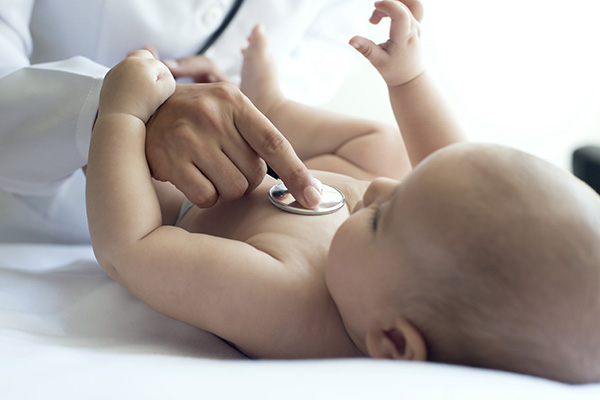 Baby having breathing checked by clinician